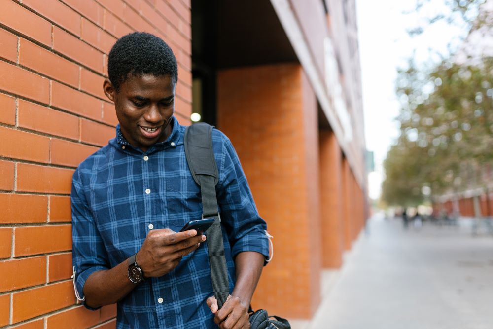 Photo d'un homme regardant son téléphone dans la rue