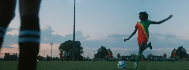 une jeune femme africaine joue au football