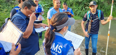 un grupo de personas representantes de la ops ayudan a habitantes a descacharrar contra el dengue