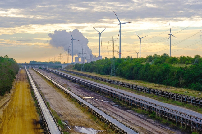 Schienen im Vordergrund, Windräder im Hintergrund