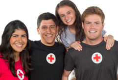 four happy people posing in red cross t-shirts smiling at the camera