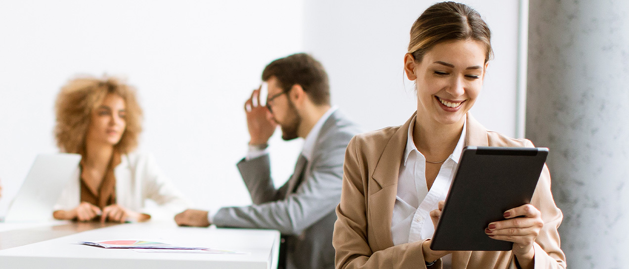 senhora com um tablet na mão e numa reunião