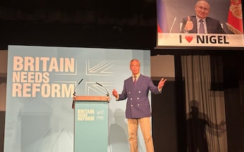 A remote-controlled screen operated by the political activist group, Led By Donkeys, lowers as Reform UK leader Nigel Farage speaks at a campaign rally at the Columbine Centre in Walton-on-the-Naze