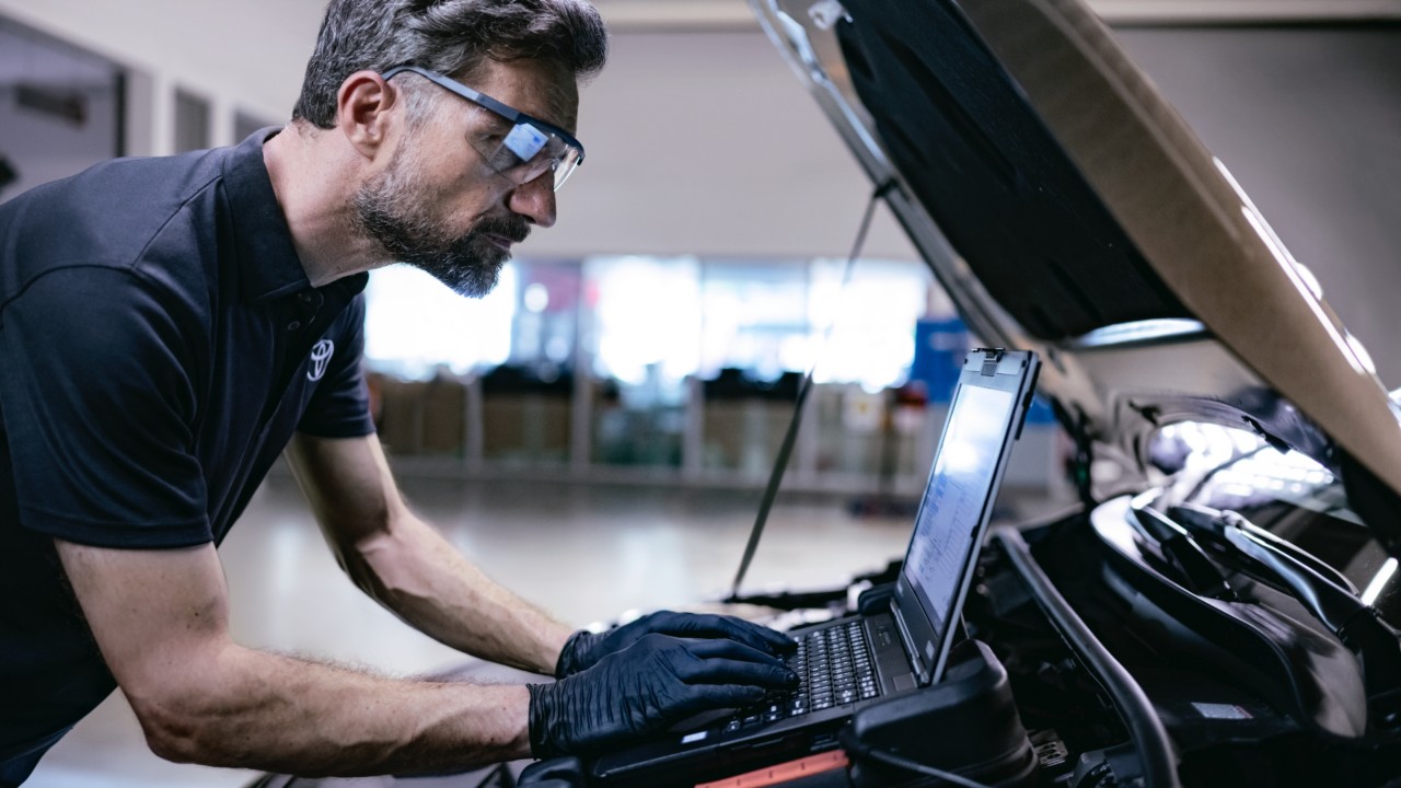 Toyota Werkstattmitarbeiter beim Auslesen der Fahrzeugdaten