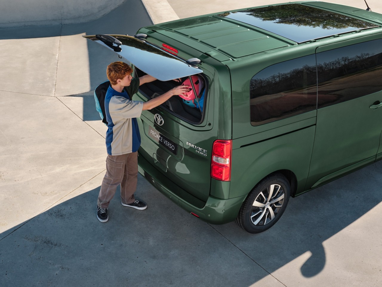 Ein Junge stellt Gepäck den Toyota Proace Verso