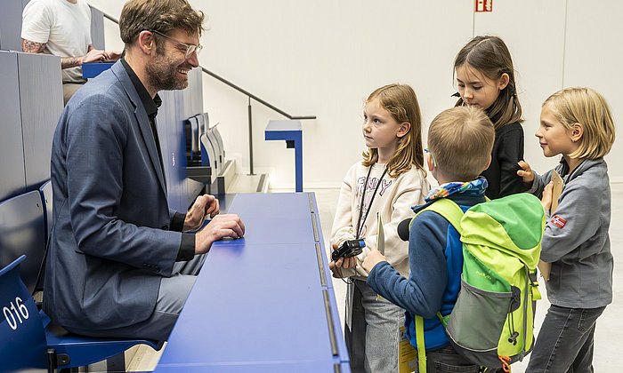 Kinder-Reporterinnen und -Reporter im Interview mit Prof. Karsten Köhler bei der KinderUni München am TUM Campus im Olympiapark am 25.10.2024.