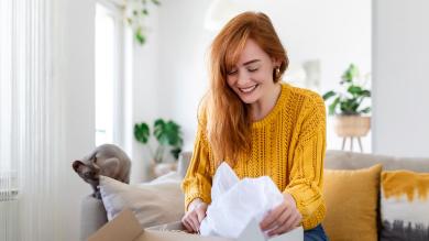 Junge Frau packt Paket aus