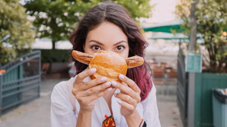 Junge Frau mit Bratwurst im Brötchen