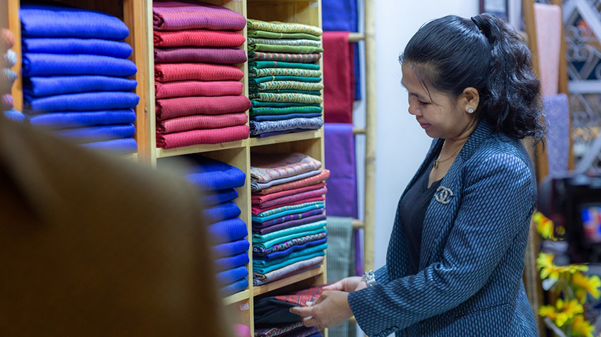 Photo of Sopheap, the founder of KTK Enterprise, inspecting her products