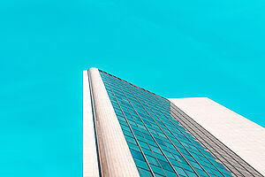 Hochhaus mit Glasfenstern und blaume Himmel