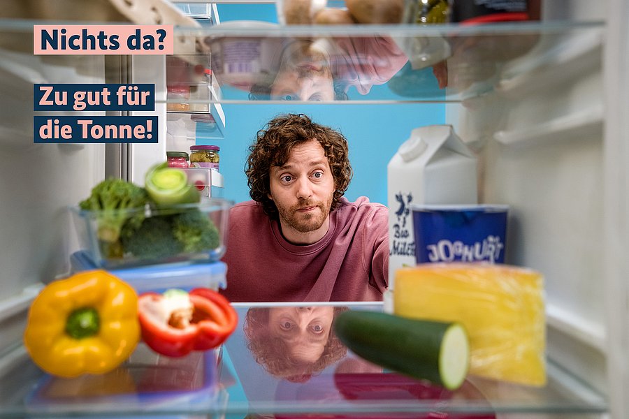 Mann schaut überlegend in den Kühlschrank, dort befindet sich Gemüse und Milch, Schrift: Nichts da? Zu gut für die Tonne!